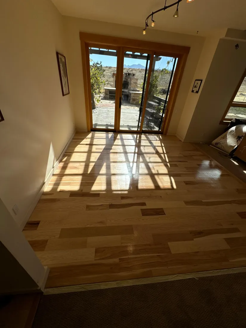 Mixed width planks in varied tones running toward patio doors