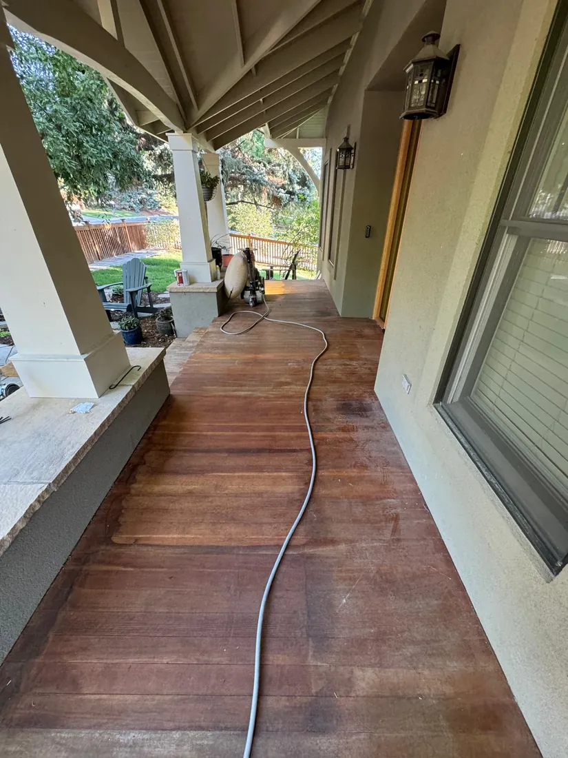 A wood floor halfway through refinishing, sanded boards meeting the old finish