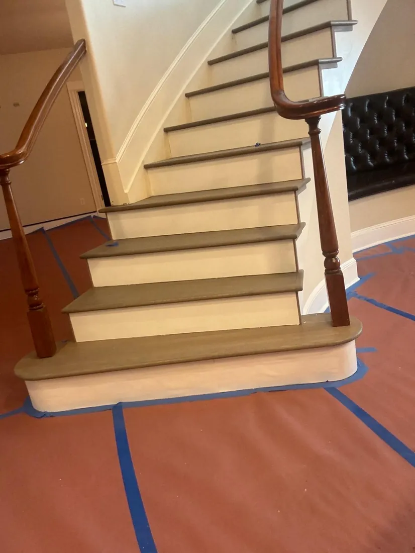 Curved staircase with new treads in place and floors masked off
