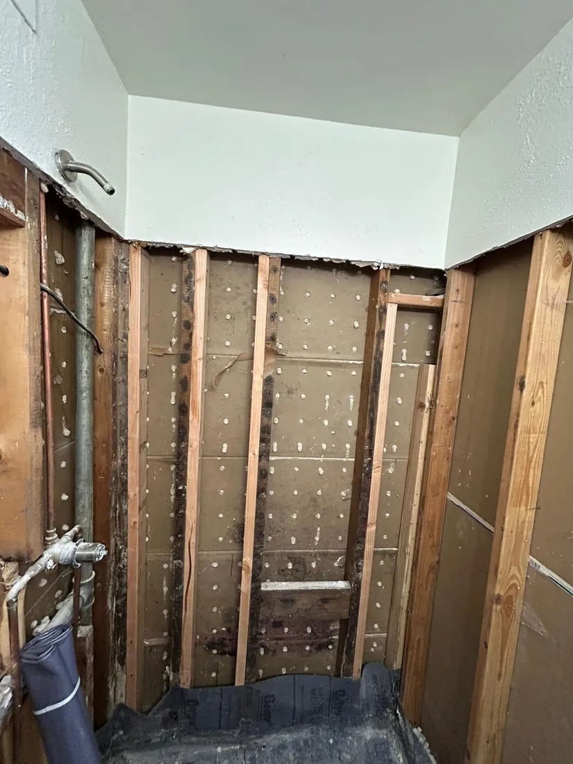 Shower walls stripped to studs with waterproofing membrane going in